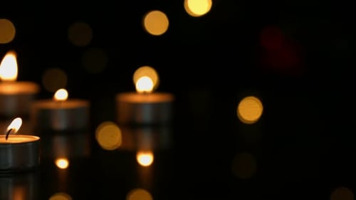 Burning Tea Light Candles Glowing in the Dark