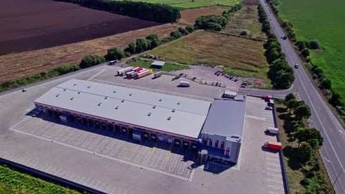 Distribution Warehouse with Trucks Aerial View