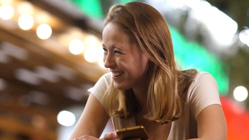 Cute woman laughing and texting message on her phone
