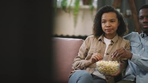 Couple Watching Television Together Eating Popcorn