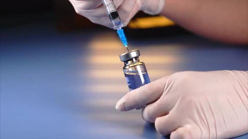 Syringe draws medicine from glass vial
