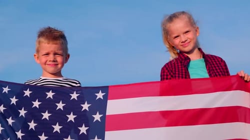 Children Hold American Flag on Sunny Day