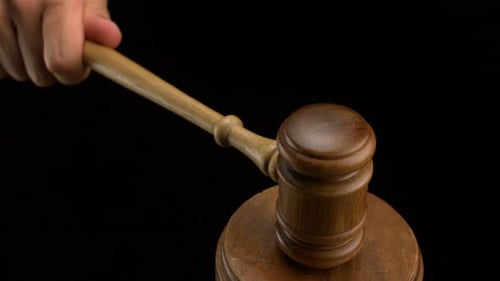 Hand Strikes Wooden Gavel for Law and Justice