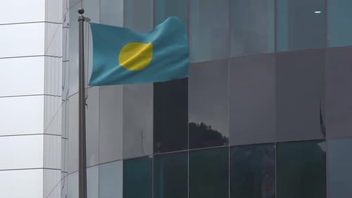Palau Flag Waving on Flagpole with Modern Building Background
