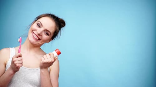 Smiling Woman Holding Toothbrush and Toothpaste