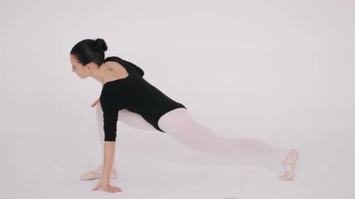 Fit Young Ballerina Stretching in White Dance Studio Isolated