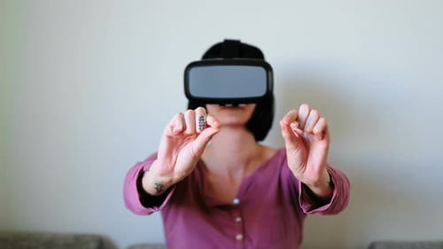 Frau benutzt Virtual-Reality-Headset im Wohnzimmer 4k