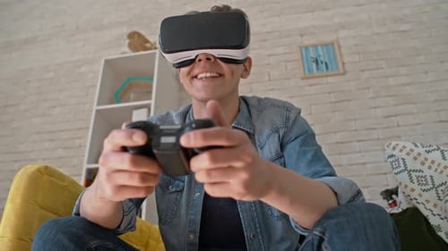 Young Adult Playing Video Game with VR Headset