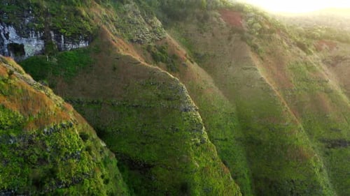Smooth Drone Flight Beside the Grassy Slopes of Hawaiian Mountain Range at Sunset