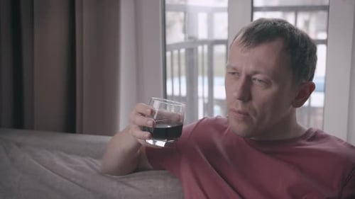 Man Drinking Dark Liquid in the Home