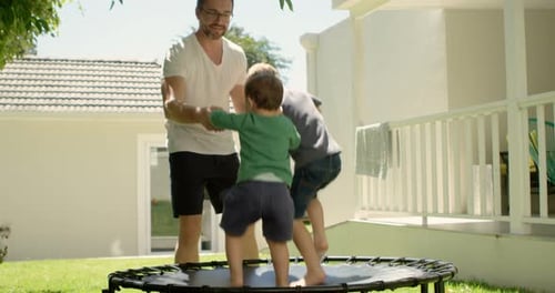 Padre jugando con niños en el trampolín 4k