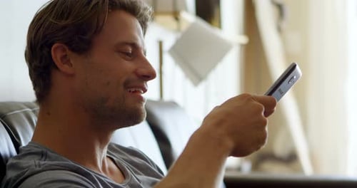 Man using mobile phone in living room 4k