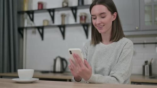 Woman Using Smartphone in Kitchen