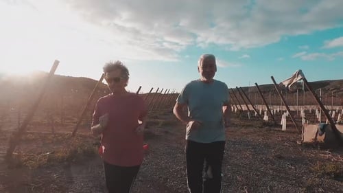 Senior Couple Jogging Together on Rural Dirt Path