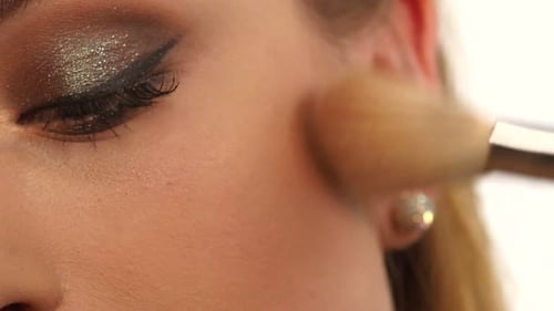 Make-up-Mädchen, Damen, Teenager-Gesicht mit Make-up-Pinseln und einem Rouge. Nahaufnahme