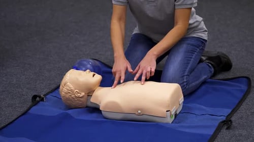 Adult Demonstrates CPR on Mannequin Dummy