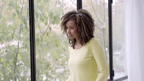 Woman Smiling Near Window in Home Setting