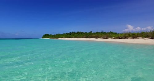 Wide angle fly over copy space shot of a white sand paradise beach and aqua blue ocean background