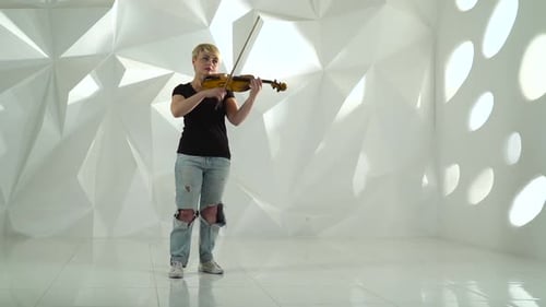 Violinist Performs a Musical Composition on a Violin in a White Studio