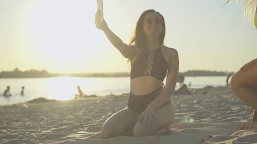 Friends Taking Selfies at Beach During Golden Hour