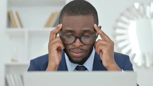 Businessman Working on Computer Rubbing Temples