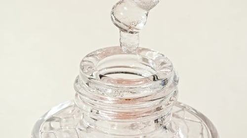 Clear Liquid Dripping Into Decorative Glass Bottle