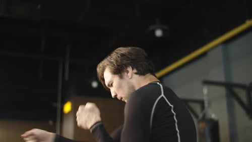 Active Male Athlete Boxing with Fists at Gym. Boxer Warming Up in Sport Club