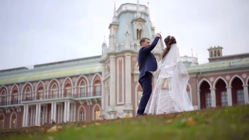 Happy Newlyweds Dancing in Front of an Elegant Building