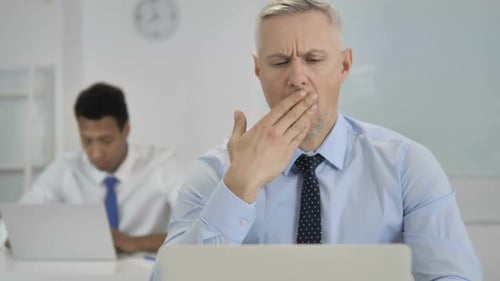 Tired Grey Hair Businessman Yawning at Work