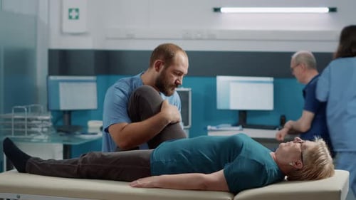 Physical Therapist Massaging Patient's Leg in Clinic