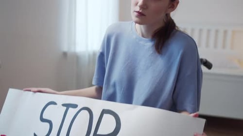 Woman in Wheelchair Holds Disability Rights Sign