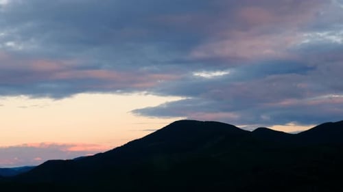 Mountain Range Silhouette at Sunset with Colorful Clouds