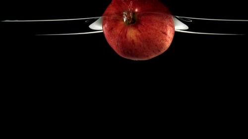 Pomme rouge au ralenti tombant dans l'eau