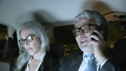 Geschäftspartner, die nachts im Auto fahren und arbeiten