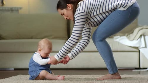 Young Mother Encouraging Baby to Walk