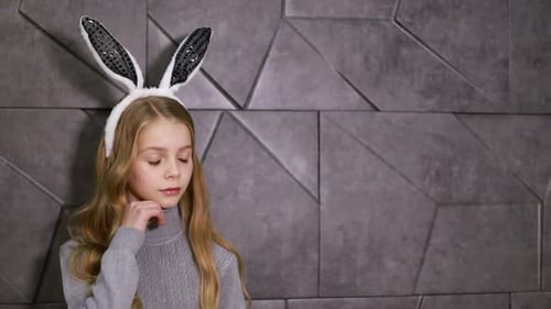 Girl With Bunny Ears Posing in Front of Wall