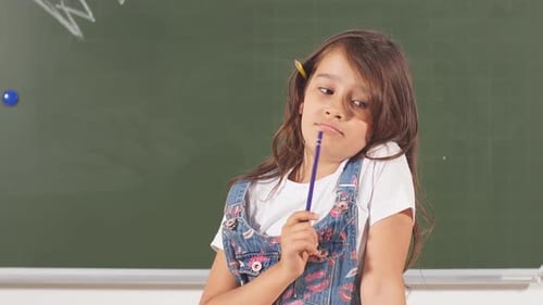 Pensive Young Girl Holding Pencil in Classroom