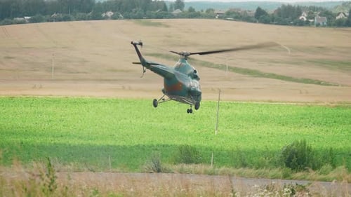 Military Helicopter Hovering Over Rural Field