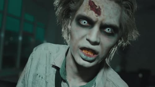 Scary Zombie with Makeup Standing in Dark Room