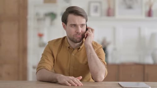 Young Man Talking on Phone in Office