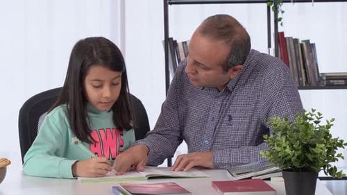 Father Helping Daughter with Homework at Home