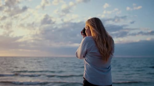Photographer Using Slr Camera On Beach