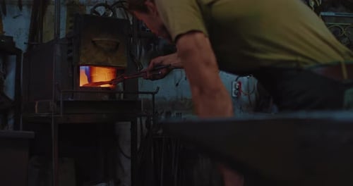 Skilled Craftsman Forging Metal in a Fiery Furnace