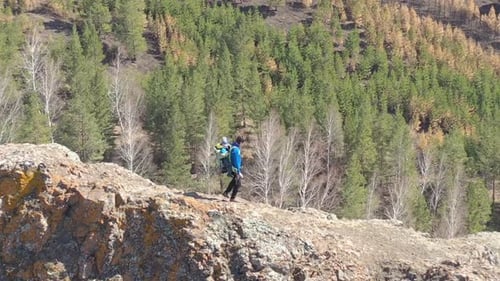 Epic Drone Shot of a Young Tourist Father with His Young Son Sitting in a Backpack. Family Travel in