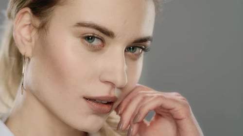 Blonde Woman Posing with Hoop Earrings in Studio