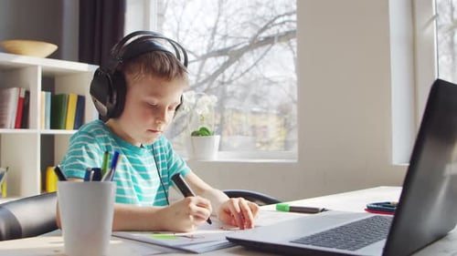 Boy Drawing with Headphones at Desk