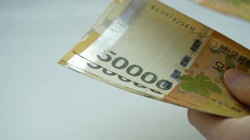 Hand Counting 50000 South Korean Won Currency