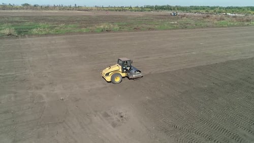 Aerial View of a Compactor Leveling the Soil in the Field Heavy Machinery
