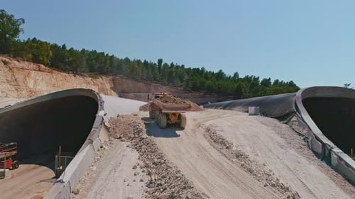 Aerial footage of large highway construction project with tunnels and bridges