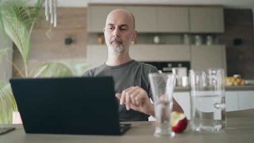 Man Using Laptop for Video Call at Home